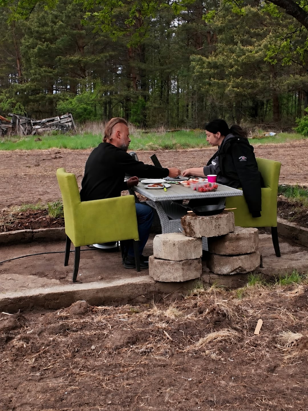 Natalia and Siarhei at a table under a tree before the terrace was built